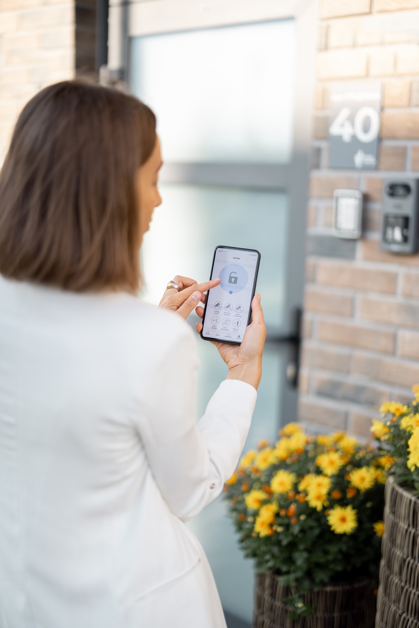 female-closes-the-door-or-turns-on-the-house-alarm-with-phone.jpg